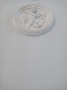 Na zdjęciu widoczny medalion - naścienny element dekoracyjny przedstawiający putto
