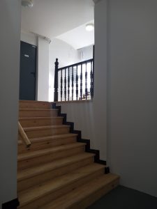 Widoczne na pierwszym planie jasne schody w klatce schodowej