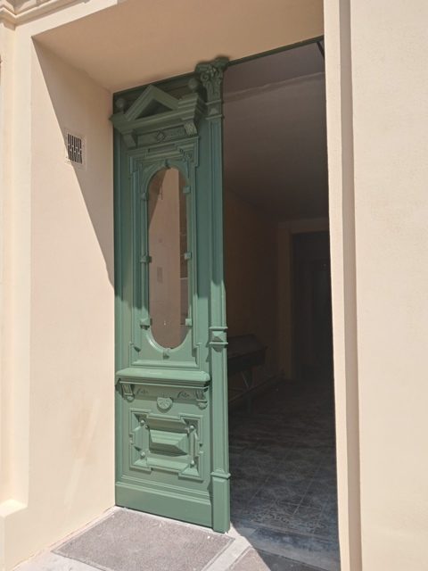 Brama wejściowa do budynku w kolorze zielonym