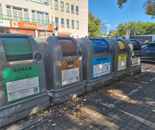 Widok na systemowe pojemniki na śmieci; szare pojemniki z widocznymi frakcjami