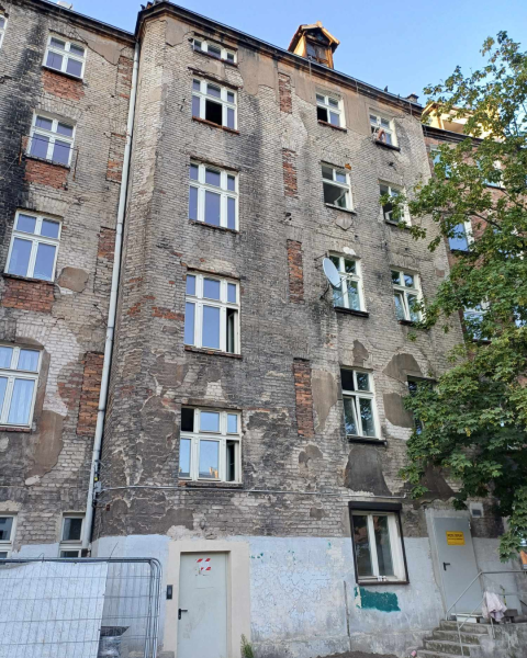 Widok na miejską kamienicę bez obróbek tynkarskich