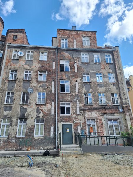 Zniszczona elewacja frontowa kamienicy