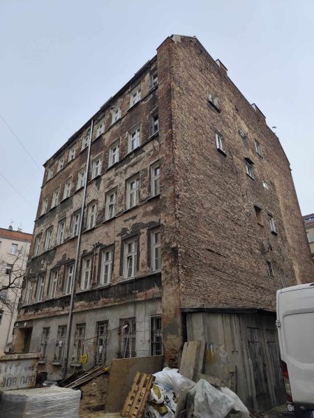 Oficyna i zdjęcie robione w takie sposób, że widoczny jest dront jak i boczna ściana; kamienica zniszczona, wymagająca remontu