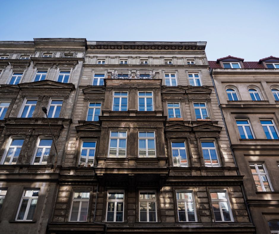 Zdjęcie przedstawia fasadę miejskiej zabytkowej kamienicy