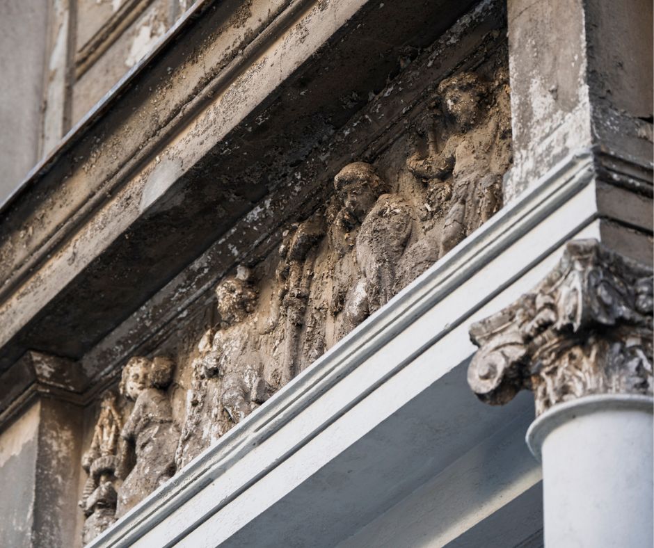 Duże zbliżenie na fragment zniszczonego tympanonu na budynku