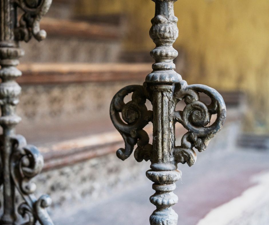 Fragment metalowego detalu na schodach. Widoczne piękne zdobienia